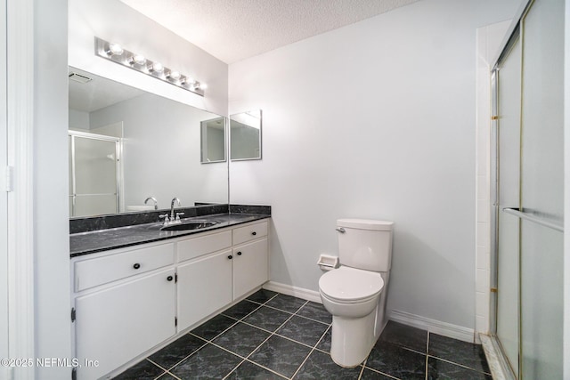 bathroom featuring vanity, a textured ceiling, toilet, and a shower with door