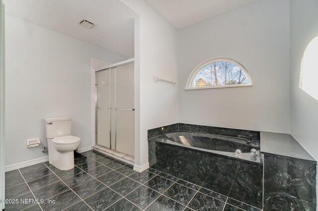 bathroom featuring shower with separate bathtub, toilet, and a textured ceiling