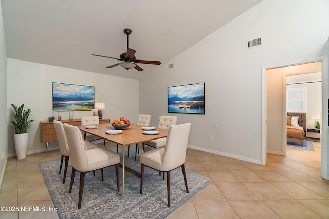 tiled dining area with high vaulted ceiling and ceiling fan