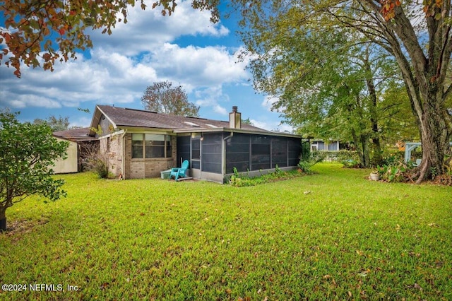 back of house with a lawn and a sunroom