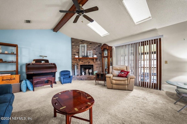 living room featuring ceiling fan, lofted ceiling with skylight, a textured ceiling, a fireplace, and carpet