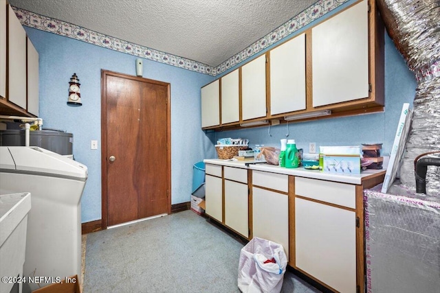 washroom with cabinets, a textured ceiling, water heater, light colored carpet, and washer / clothes dryer