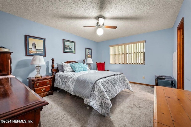 bedroom with ceiling fan, light colored carpet, and a textured ceiling