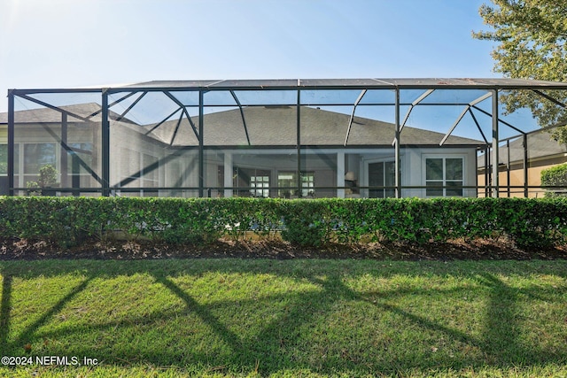 back of house featuring a lanai and a lawn