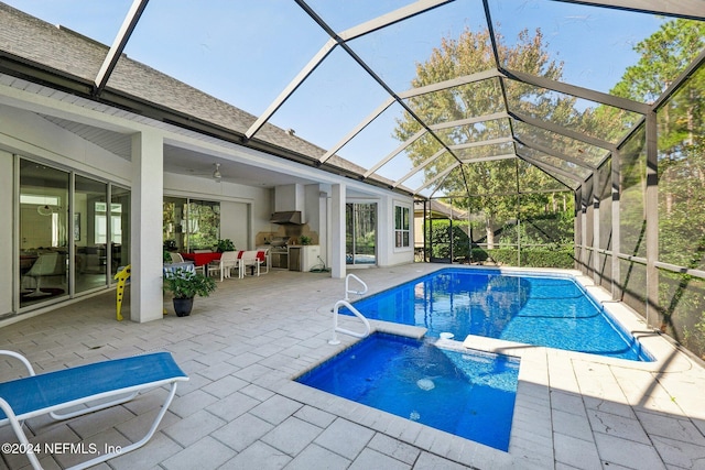 view of pool featuring a lanai, a patio, ceiling fan, and an in ground hot tub