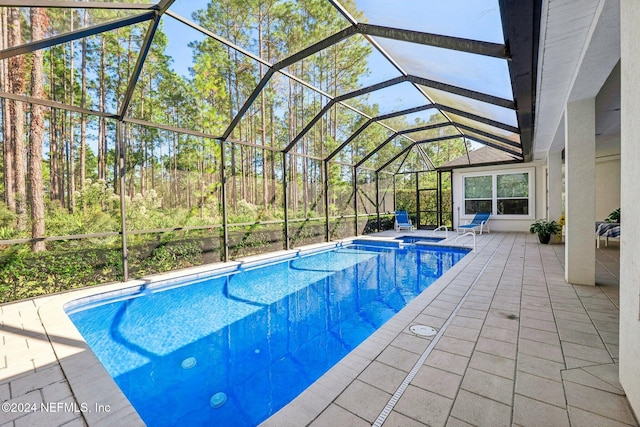 view of pool with a patio and glass enclosure