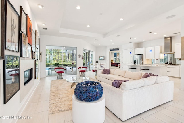 tiled living room featuring a tray ceiling