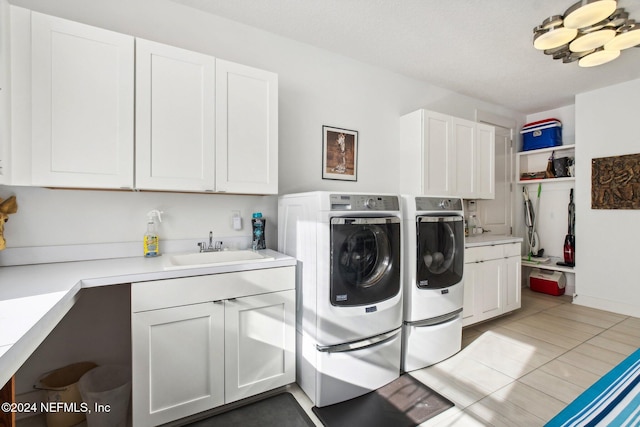 laundry area featuring tile patterned floors, sink, cabinets, a textured ceiling, and independent washer and dryer