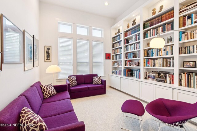 sitting room featuring built in shelves and carpet flooring