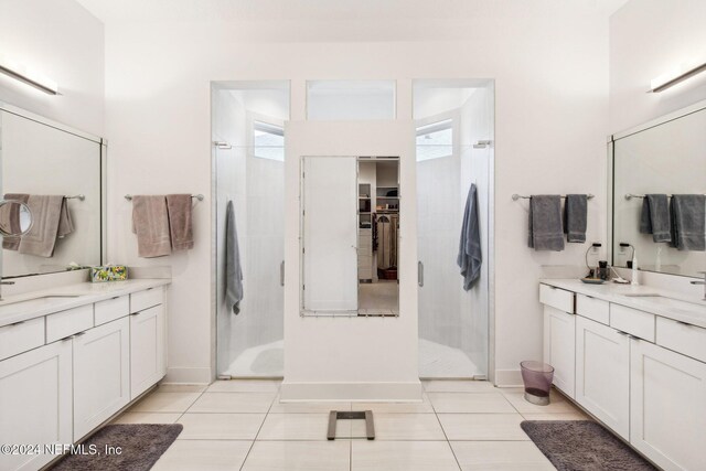 bathroom featuring tile patterned flooring, vanity, and a shower with door