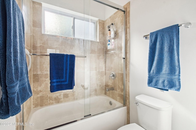 bathroom featuring shower / bath combination with glass door and toilet