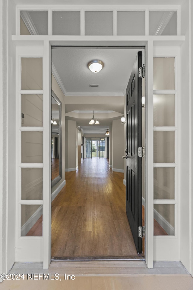 135 N Champions Way Unit 212, Saint Augustine, FL 32092 - corridor with ornamental molding, a chandelier, wood finished floors, and built in shelves