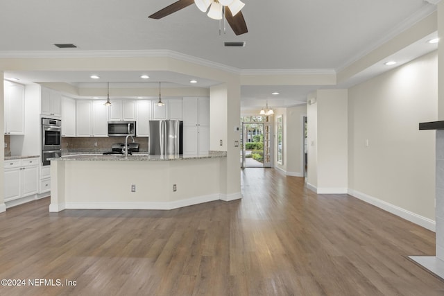 kitchen with stainless steel appliances, hanging light fixtures, white cabinets, light stone countertops, and light wood-type flooring