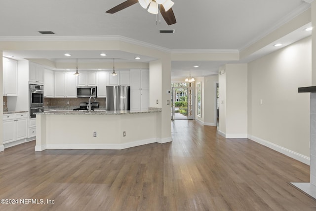 135 N Champions Way Unit 212, Saint Augustine, FL 32092 - kitchen with stainless steel appliances, ornamental molding, wood finished floors, white cabinets, and recessed lighting