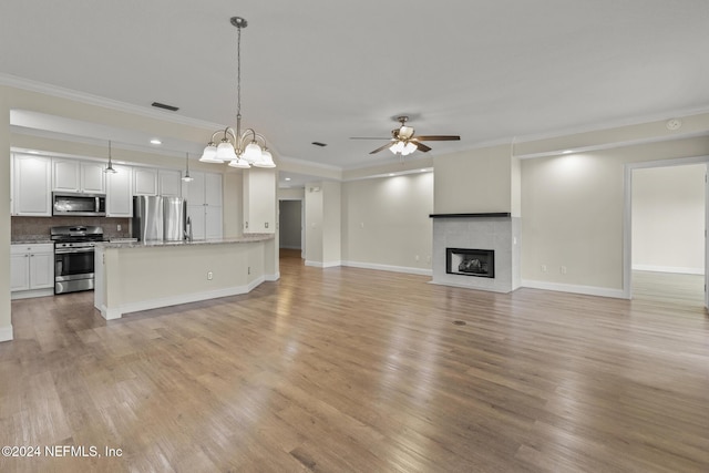 unfurnished living room featuring light wood-style floors, a fireplace, visible vents, and a ceiling fan