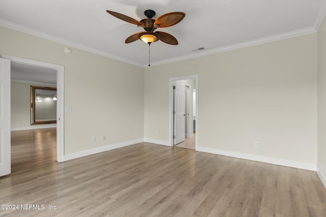 unfurnished room featuring ornamental molding, light wood-type flooring, visible vents, and baseboards