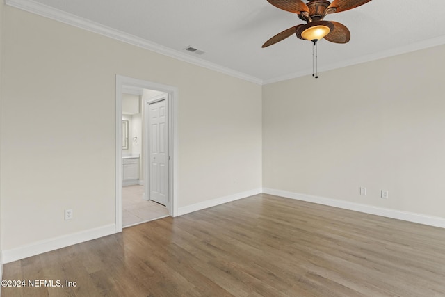 unfurnished room with light wood finished floors, visible vents, ornamental molding, a ceiling fan, and baseboards