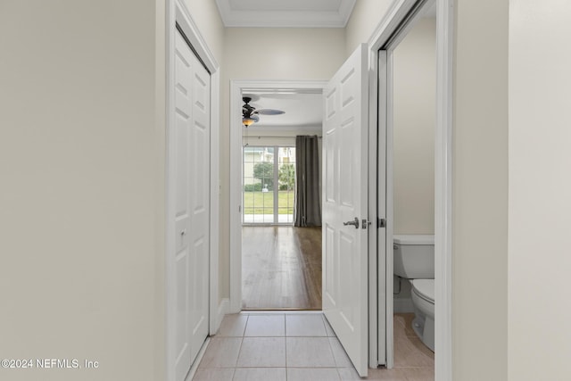 hall featuring ornamental molding and light tile patterned flooring