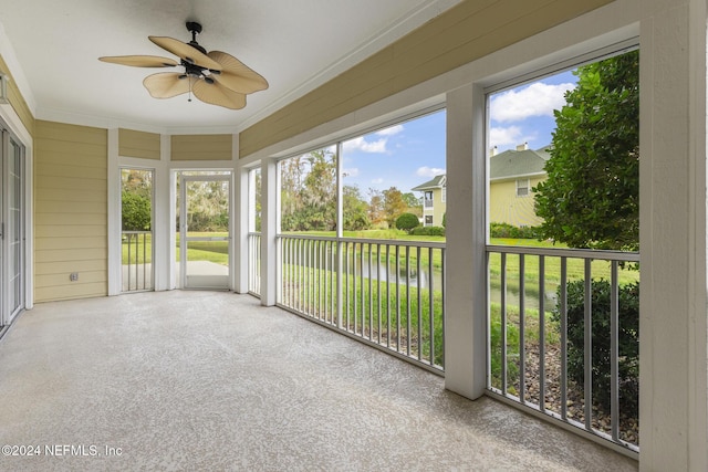 unfurnished sunroom featuring a water view and a ceiling fan