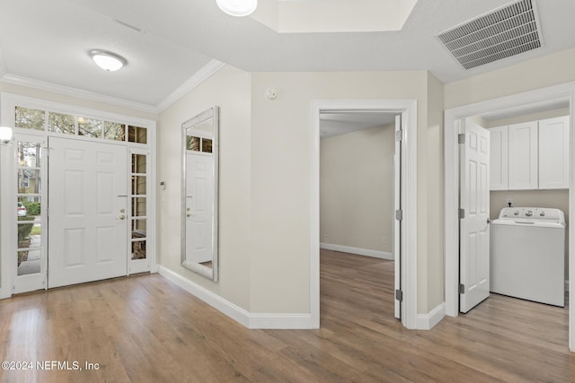 135 N Champions Way Unit 212, Saint Augustine, FL 32092 - entrance foyer featuring washer / dryer, ornamental molding, and light wood-style flooring