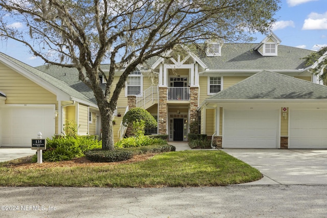 135 N Champions Way Unit 212, Saint Augustine, FL 32092 - view of front facade with a shingled roof, an attached garage, stone siding, and driveway