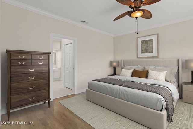 bedroom with baseboards, visible vents, connected bathroom, ornamental molding, and light wood-type flooring