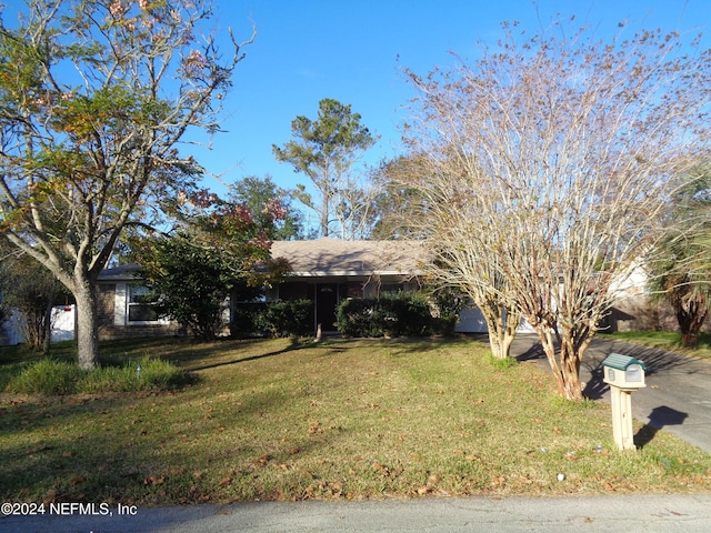 obstructed view of property featuring a front lawn