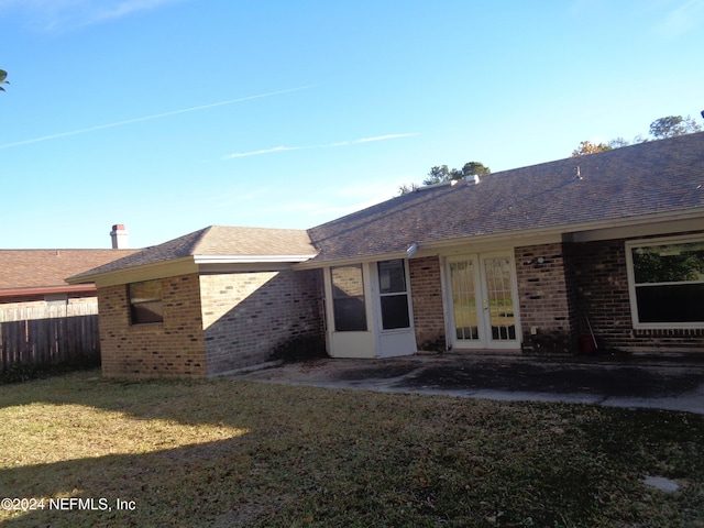 rear view of property featuring a yard and french doors