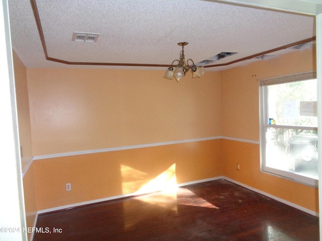 unfurnished room with hardwood / wood-style floors, a notable chandelier, and a textured ceiling