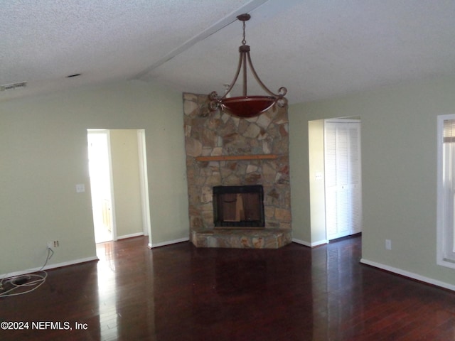 unfurnished living room featuring a textured ceiling, a fireplace, dark hardwood / wood-style flooring, and vaulted ceiling