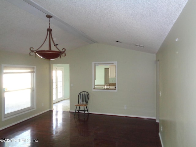 unfurnished living room with a textured ceiling, lofted ceiling with beams, and dark wood-type flooring