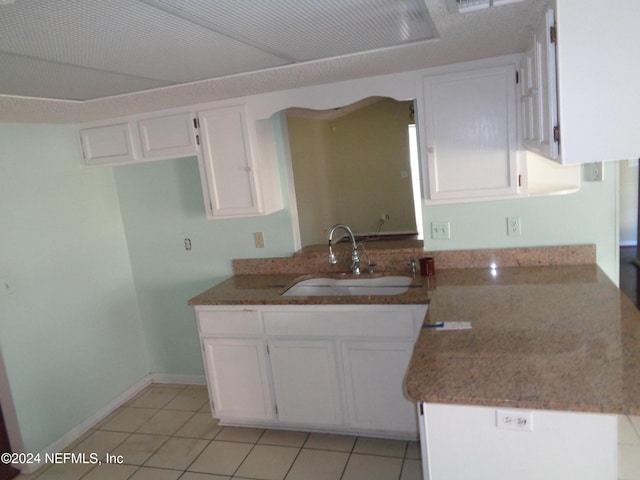 kitchen with sink, white cabinets, and light tile patterned flooring