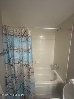 bathroom featuring shower / tub combo with curtain and toilet