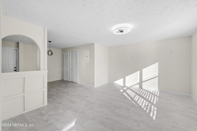 unfurnished room featuring a textured ceiling