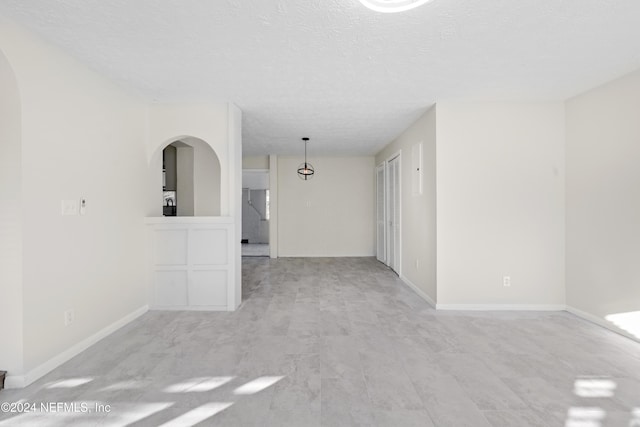 spare room featuring light hardwood / wood-style floors and a textured ceiling