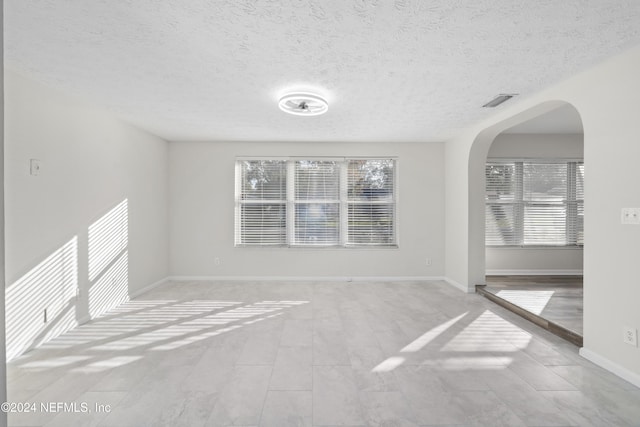 unfurnished room with a textured ceiling