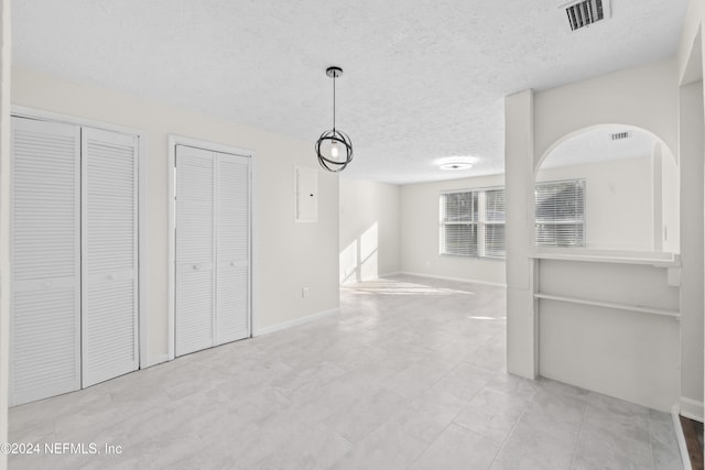 interior space with electric panel and a textured ceiling