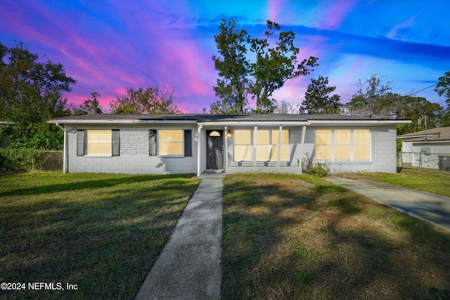 single story home with a lawn