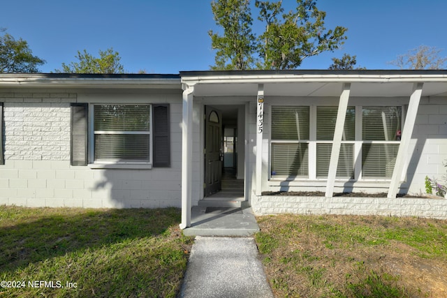 view of exterior entry with a yard