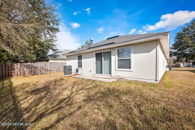 back of house with central AC unit, a lawn, and a patio area