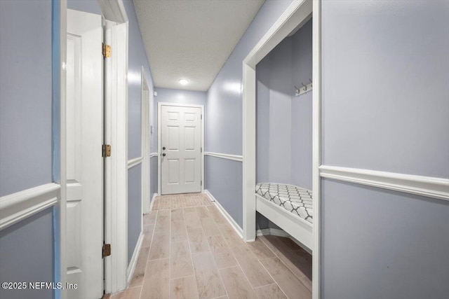 mudroom with light hardwood / wood-style floors and a textured ceiling