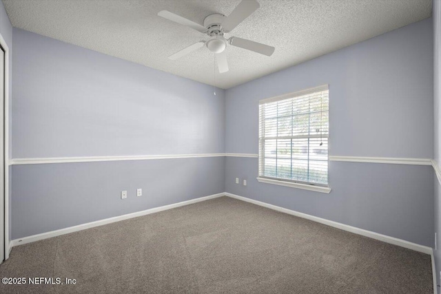 carpeted spare room featuring ceiling fan and a textured ceiling