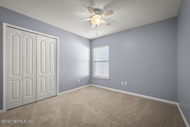 unfurnished bedroom with light carpet, a textured ceiling, a closet, and ceiling fan