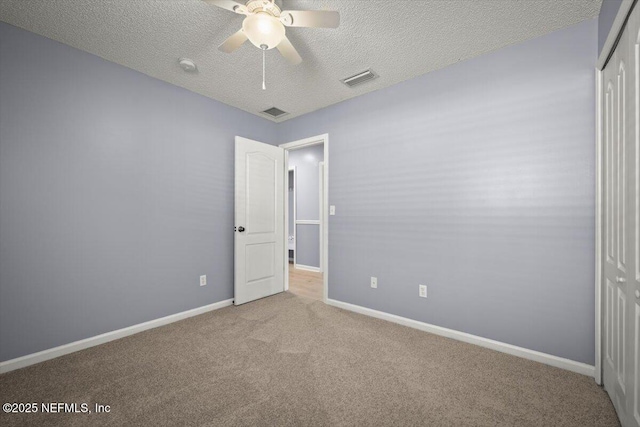 unfurnished bedroom with light carpet, a textured ceiling, ceiling fan, and a closet