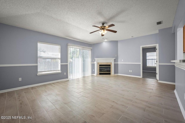 unfurnished living room with a textured ceiling and ceiling fan