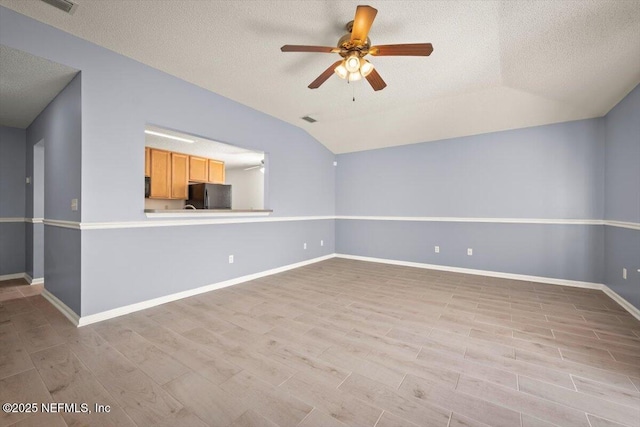 unfurnished living room featuring vaulted ceiling, light wood-type flooring, and ceiling fan