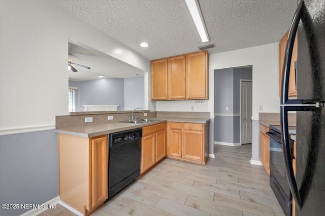 kitchen featuring light brown cabinetry, sink, a textured ceiling, and black appliances