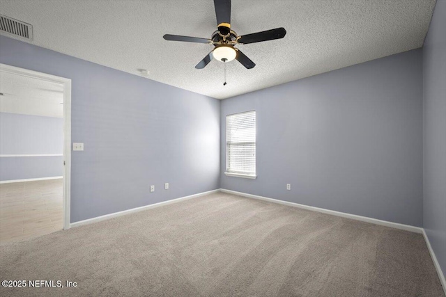 carpeted spare room with ceiling fan and a textured ceiling