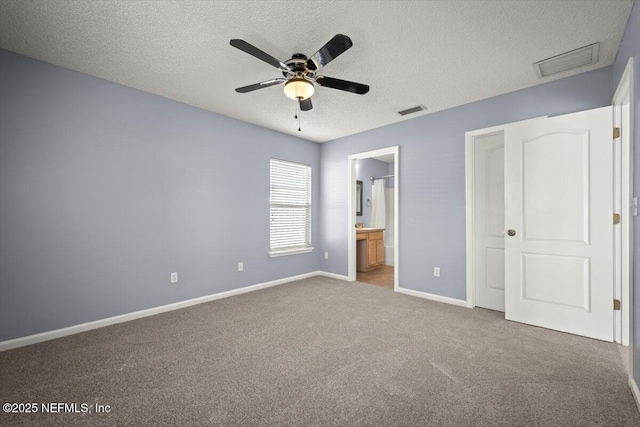 unfurnished bedroom featuring connected bathroom, a textured ceiling, ceiling fan, and carpet flooring