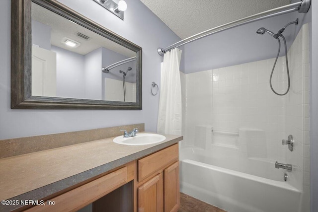 bathroom with vanity, shower / tub combo with curtain, and a textured ceiling